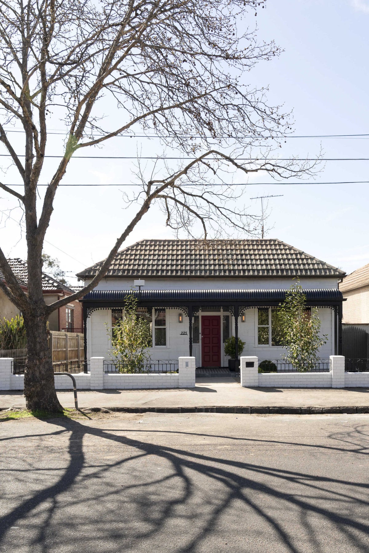 House with a white picket fence and tree on a clear day