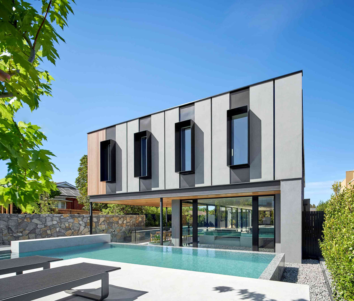 Modern house with a pool and garden under a clear blue sky