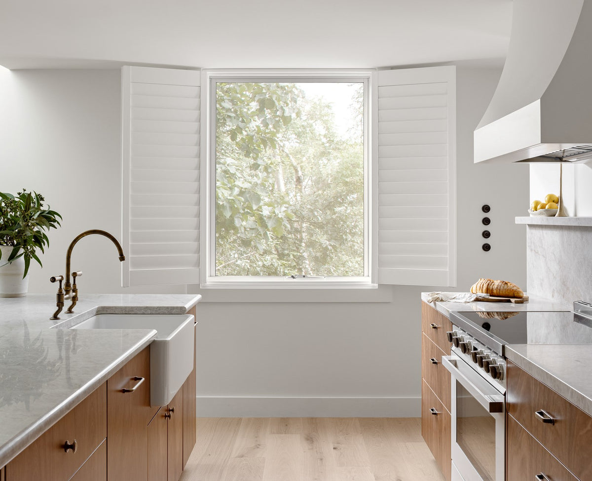 Modern kitchen with a window, sink, and appliances.
