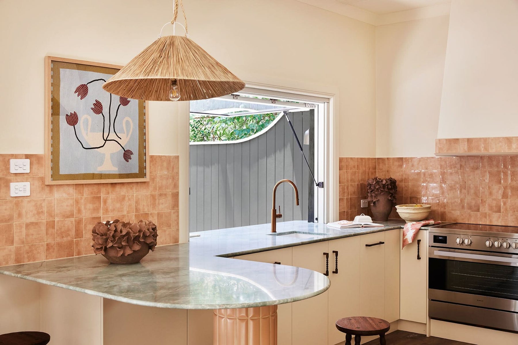 Modern kitchen with marble island, stainless steel appliances, and a view of the outdoors.