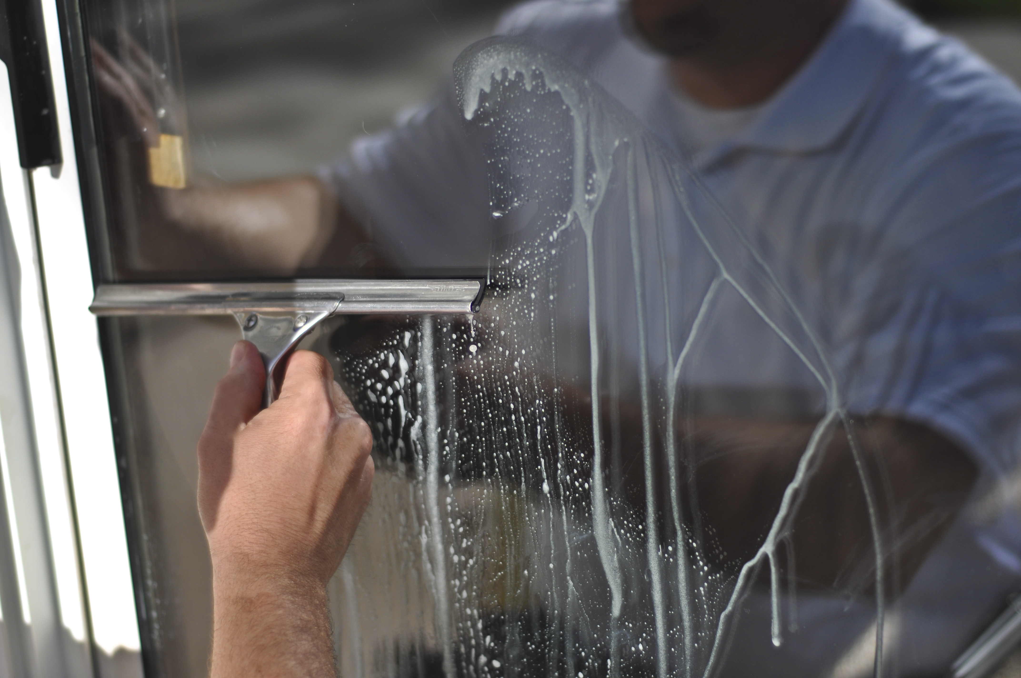 man cleaning glass window